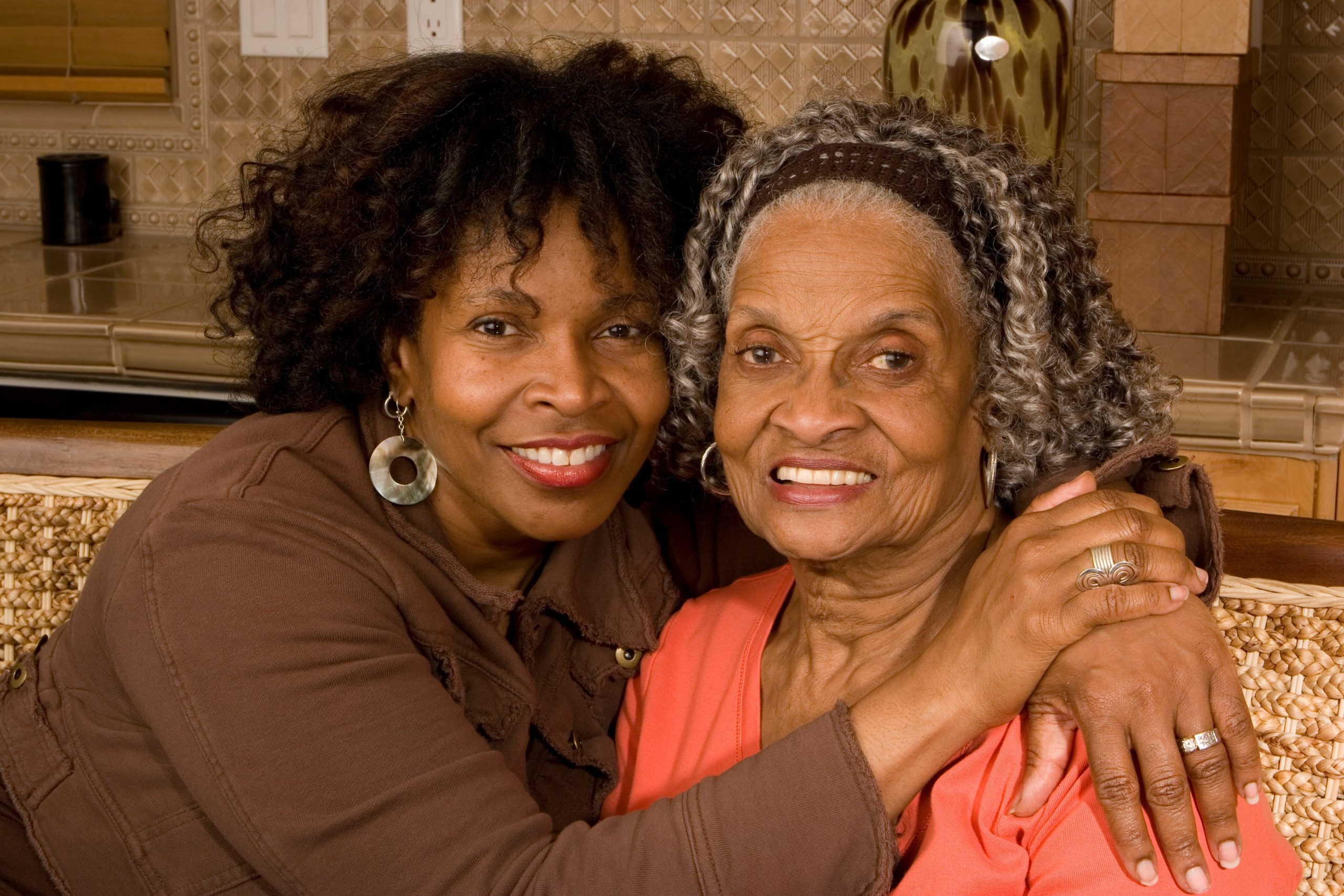 Woman hugging senior woman with arms around her shoulders